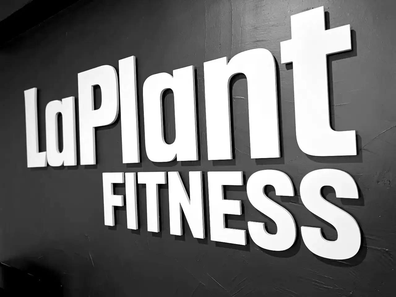 Dimensional wall signage of the LaPlant Fitness logo inside a modern, private personal training gym in Marin, CA.
